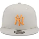 beige-snapback-kappe-mit-flachem-schirm-und-orangefarbenem-logo-9fifty-side-patch-der-new-york-yankees-mlb-von-new-era